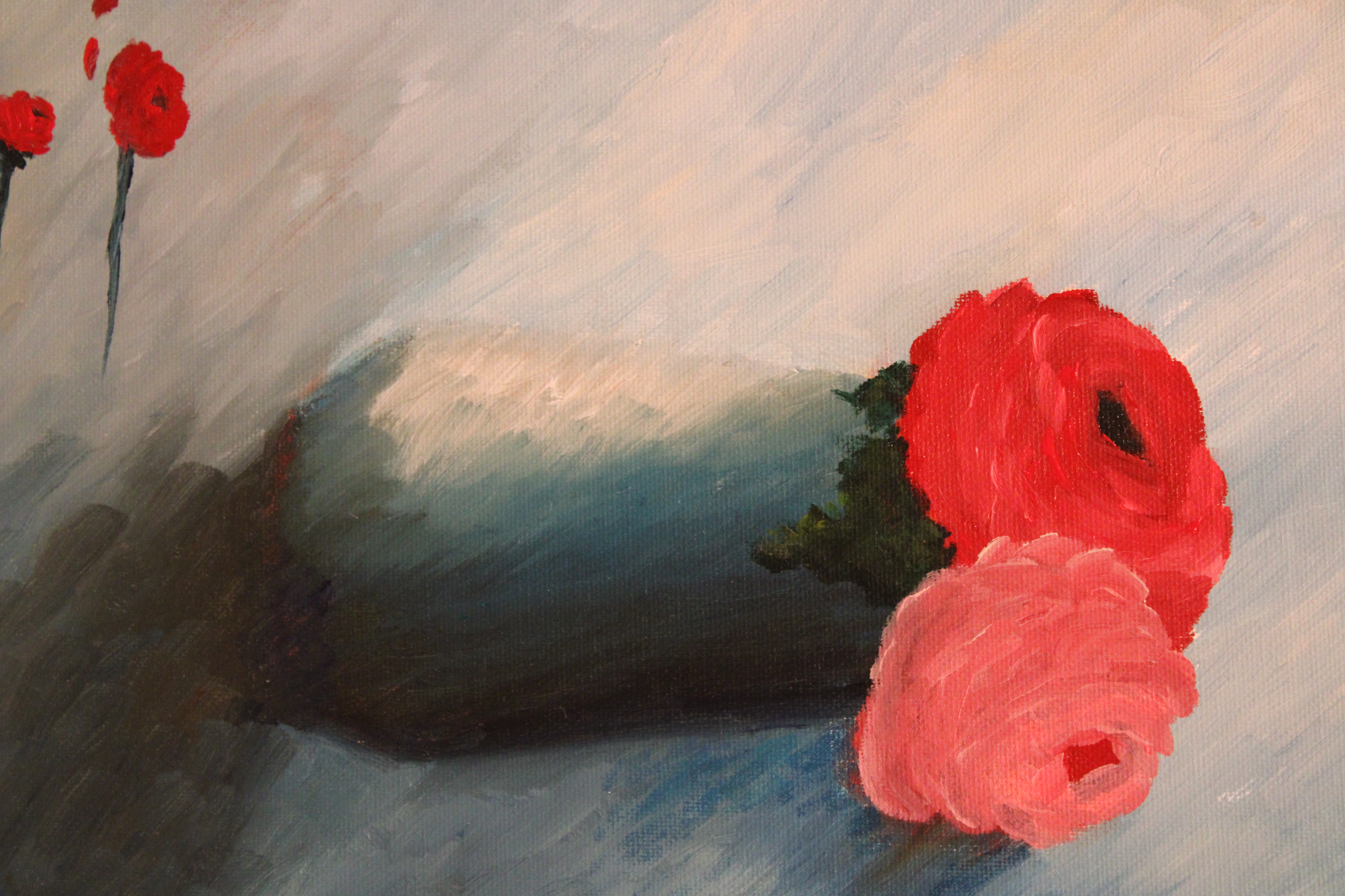 A red and a pink rose in a blue vase against a blue background.
